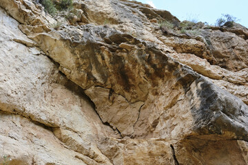 Majestic rock formation with rugged texture and natural patterns under clear sky