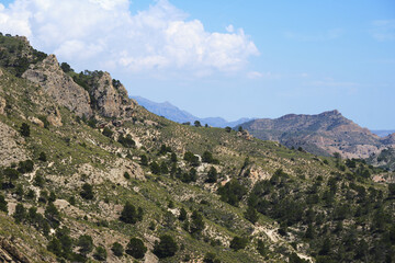 Rugged mountain landscape with lush green hills and dramatic sky