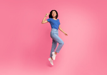 Euphoria Concept. Full length portrait on energetic young asian woman jumping and showing victory v...