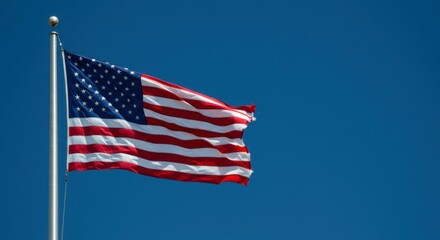 United States flag flying high with clear blue sky backdrop
