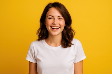 Fototapeta premium Portrait of a Cheerful Young Woman Wearing White Shirt, Posing on Yellow Background