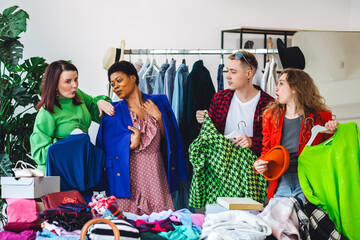 Group of friends generation z girls and boys enjoying shopping in a second hand store or swap home...
