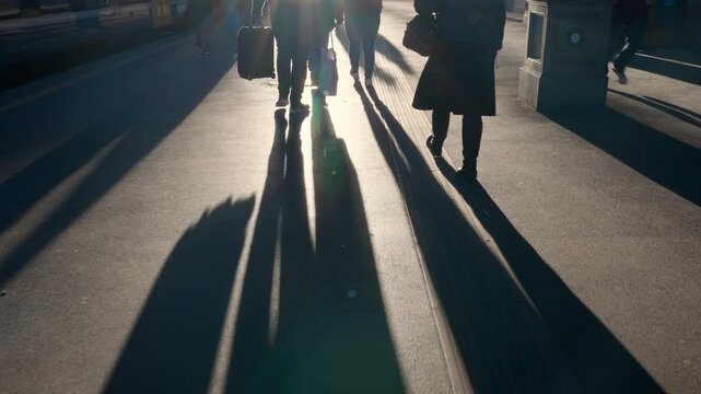 People walking in sunset in a train statin in Europe