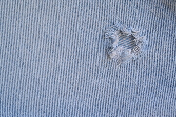 torn light grey denim surface, denim fringe , hole macro texture of blue denim, torn blue denim...