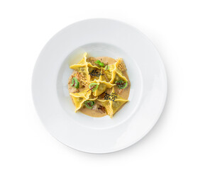 Ravioli with sauce decorated with greens in plate isolated on white background. Italian dishes, top view, close up