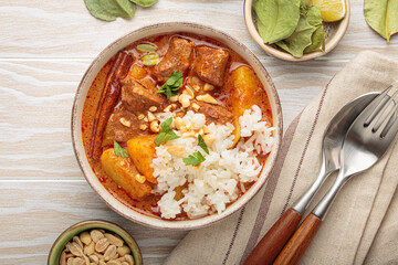 Aromatic massaman curry, a staple of thai cuisine, with tender beef, potatoes, and fluffy rice,...
