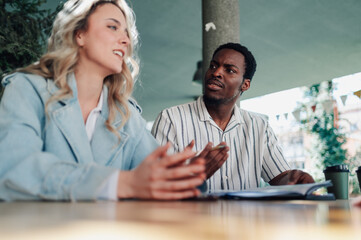 Colleagues discussing business strategy at outdoor cafe table