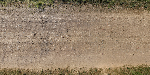 Fototapeta na wymiar top view of gravel road surface and grass shoulder