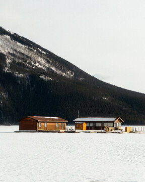 Minimalist cabins frozen lake mountains