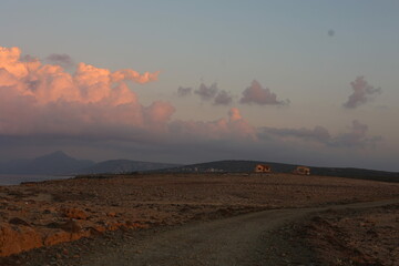 Road on the cape on the hills during sunset
