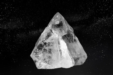 Photo of genuine uncut raw clear crystal, creative collage on a black sparkling background with stars.