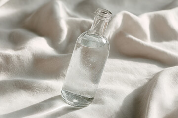 glass water bottle glistening in sunlight covered in condensation