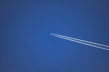 Airplane with contrail in blue sky – Tirol, Austria – December 3, 2009