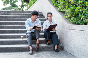 Young business man and businesswoman looking on document paper and talking about business project