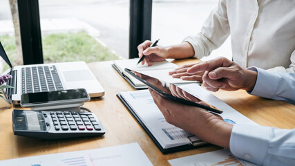 Business team are working with leader, Presentation to colleagues and business strategy and having a discussion, pointing to the graph and chart, success of cooperation partnership
