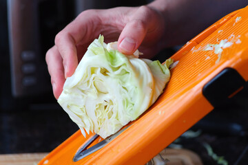 Slicing cabbage with a mandoline slicer. Cooking at home.