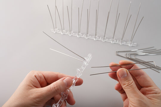 Manual assembly of anti-pigeon spikes for urban pest control systems. Ideal for architectural design firms, security services, and facility management businesses.