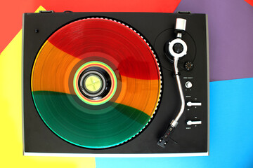 Top view of a record player. Rainbow vinyl record on the player.