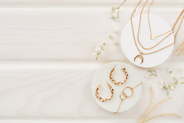 Elegant golden jewelry with decoration on wooden background, top view