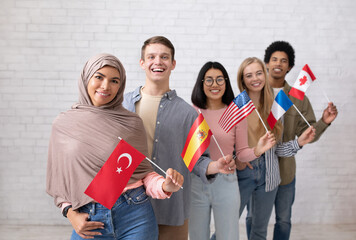 Modern exchange program and language learning. Happy young international students looking at camera...