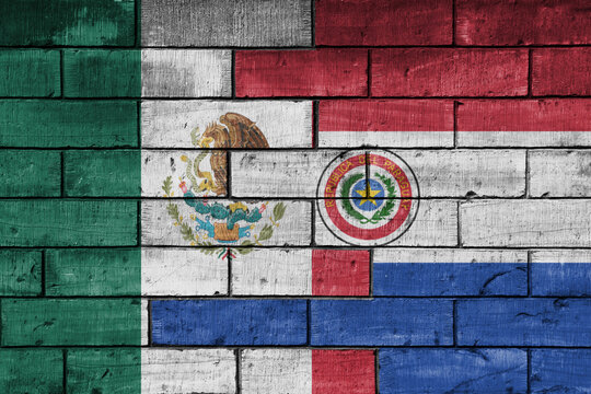 colourful painted big national flag of mexico and flag of paraguay on a massive old brick wall background. concept