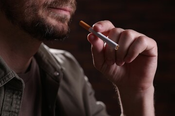 Man with cigarette on blurred background, closeup. Smoking