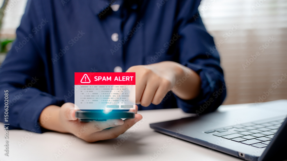 Poster hand holding smartphone with digital spam alert warning message on screen, symbolizing cybersecurity