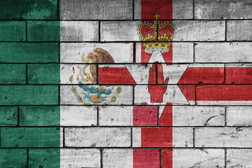 colourful painted big national flag of mexico and flag of northern ireland on a massive old brick wall background. concept