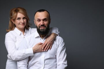 Portrait of lovely couple on grey background, space for text