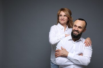 Obraz premium Portrait of lovely couple on grey background, space for text