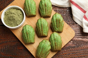 Tasty matcha madeleine cakes on wooden table, top view