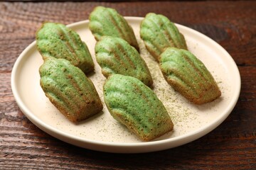 Tasty matcha madeleine cakes on wooden table, closeup