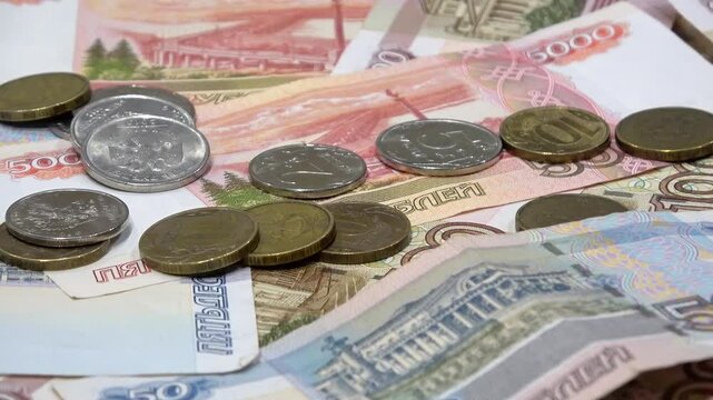 Russian ruble banknotes and coins scattered on table close up, view money currency financial background, selective focus. Concept of banking services, financial planning, economic analysis.