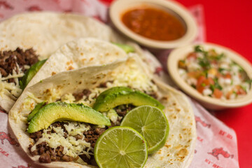 An enticing display of beef tacos filled with fresh ingredients like avocado and topped with salsa, creating a mouthwatering representation of authentic Mexican cuisine.