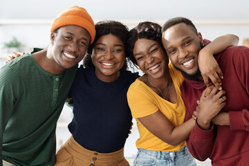 Portrait of cheerful african american millennial couples, living room interior, cute black guys and...