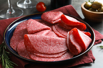 Slices of delicious sausage served on grey table, closeup