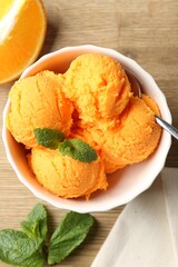 Tasty orange sorbet, fresh fruit slice and mint on wooden table, flat lay