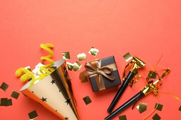 Beautiful party hat and other festive decor on red background, flat lay. Space for text