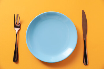 Stylish plate and cutlery on orange background, flat lay