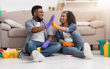 Cleaning Concept. Cheerful African American Couple Giving High Five To Each Other After Tidying...
