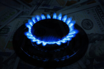 Gas burner with blue flame and dollar bills, double exposure. Gas tariff