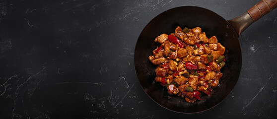 Fototapeta na wymiar Wok is filled with savory kung pao chicken with tender chicken, crunchy peanuts and vibrant vegetables, all coated in a flavorful sauce
