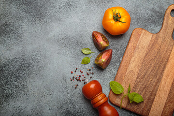 Fresh vegetables and spices on dark countertop with rustic cutting boards, top view. Healthy,...