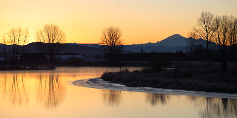 Peaceful morning with tranquil river and fiery sunrise