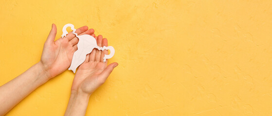 Woman with paper uterus on yellow background. Hormones concept