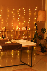 Interior of dark spa salon with couch, shelf units and glowing lights