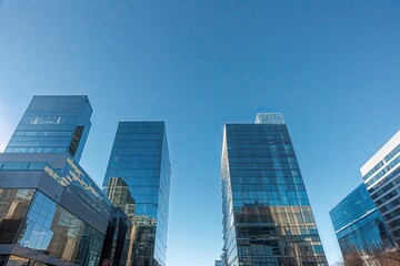 Fototapeta premium Urban Office Building Under Clear Blue Sky: Polished Glass Surfaces and Corporate Dynamics