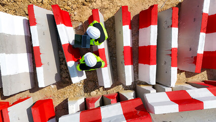 Close up top view of two construction workers in safety gear using a laptop at a worksite,...