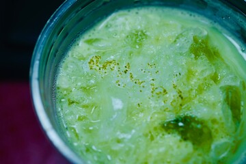 Top view of iced matcha latte, cold beverage with green layers and ice
