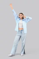 Vitrage gordijnen Young woman in headphones dancing on light background © Pixel-Shot